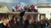 Cubanos protestan en Santiago de Cuba. Los funcionarios se subieron al techo de una vivienda para dirigirse a la multitud de manifestantes.