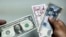 Billete de un dólar y pesos cubanos. Imagen de archivo / (Foto de YAMIL LAGE / AFP)