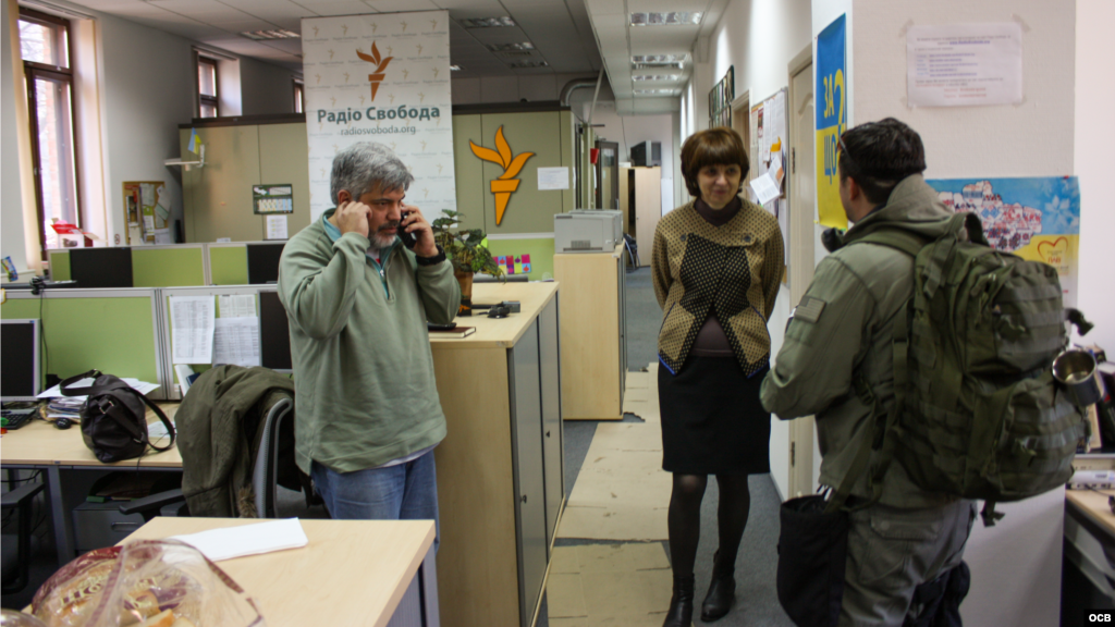 Inna Kuznetsova (centro) habla con un manifestante del Euromaidan que busca información sobre un sacerdote desaparecido.