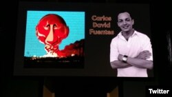 Carlos David Fuentes, junto a la caricatura premiada. (foto: Twitter/@andre_cath)