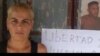 Esposa de Duniesky Ruiz, junto al cartel que pide la liberación del preso del 11J.