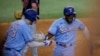 El cubano Adolis García (derecha) celebra junto a Jonah Heim (izquierda) luego de anotar la carrera de la ventaja en la octava entrada del juego ante los Guardianes de Cleveland, en Arlington, Texas. Domingo 16 de julio de 2023. (AP Foto/Gareth Patterson).
