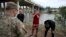Migrantes cubanos interceptados por agentes de la Guardia Nacional estadounidense tras cruzar a nado el Río Bravo, en Eagle Pass, Texas. (AP/Dario Lopez-Mills)