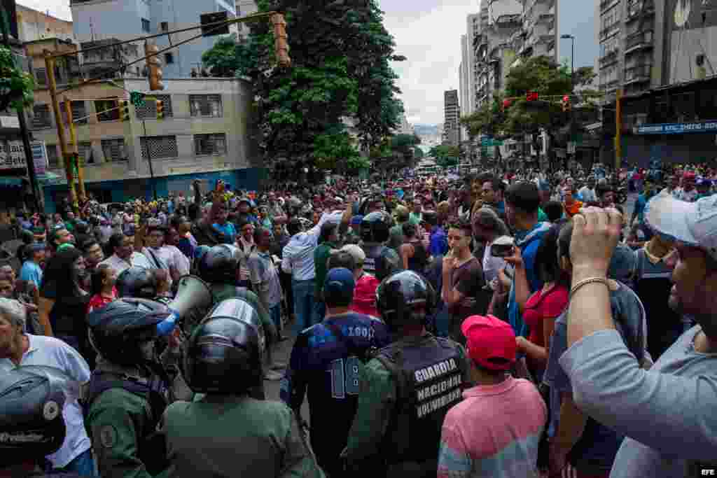 Un grupo de personas manifiestan contra miembros de la Guardia Nacional Bolivariana (GNB) hoy, jueves 2 de junio del 2016, en el centro de la ciudad de Caracas (Venezuela). La angustia por las varias horas de espera en filas interminables y el temor de n