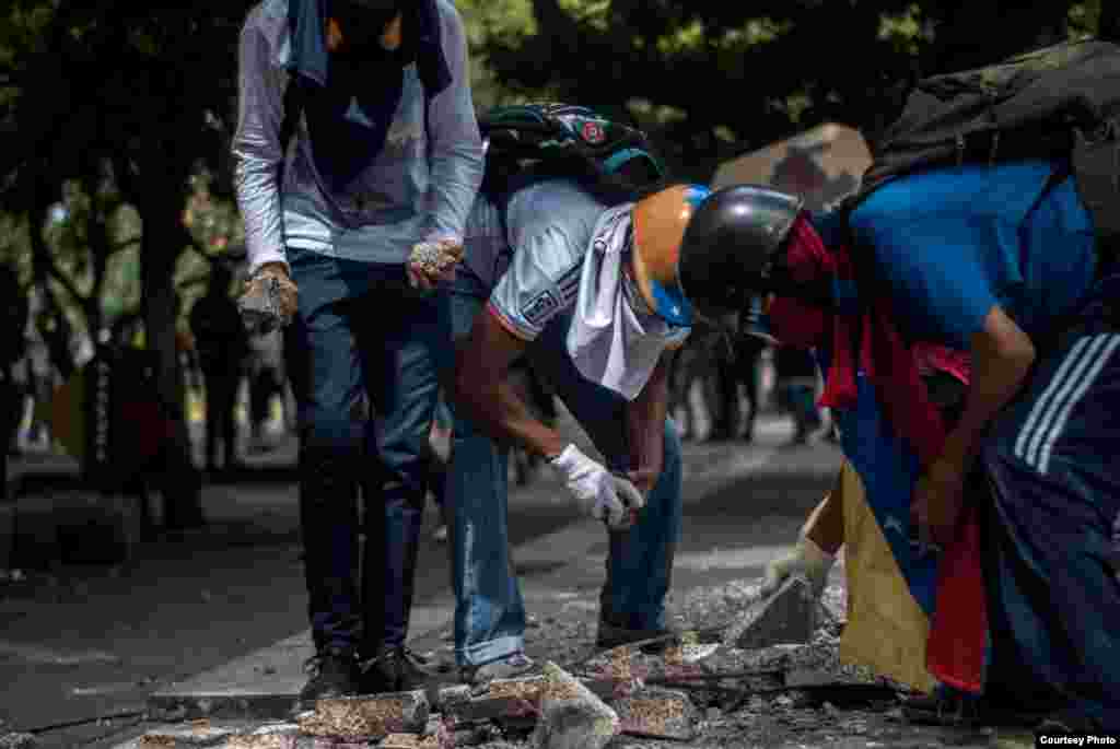Manifestantes destruyen bancos de cemento ubicados en el bulevar en Chacaito para sacar trozos pequeños de cemento y lanzarlos a efectivos de la PNB. (Foto: Juan Pablo Arraez)