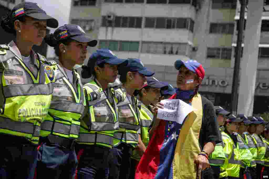 Agentes bloquean el paso a una marcha de manifestantes en Caracas (Venezuela).