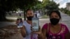 Servilia Pedroso (der.), madre del estudiante de 18 años Eloy Bárbaro Cardoso, y Yaquelin Cruz, madre de Dariel Cruz, dos manifestantes del 11J en La Güinera, muestran sus fotos. (AP/Ramón Espinosa)