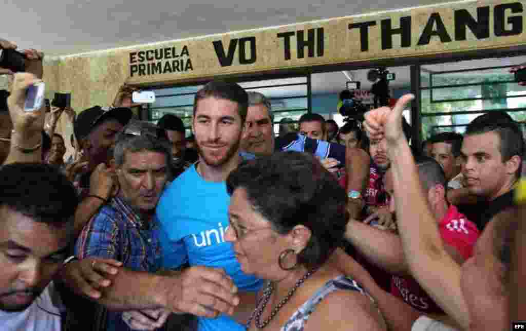 Aficionados al fútbol persiguieron al defensa madridista Sergio Ramos y lo recibieron con aplausos y gritos en la visita que cursó a una escuela habanera.  