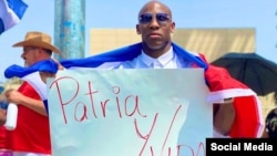 El boxeador cubano Yordenis Ugás celebrando que el pueblo de Cuba esté en las calles, con un cartel de Patria y Vida.