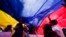 Manifestantes despliegan una bandera venezolana gigante en México DF, durante una marcha de apoyo a los resultados electorales de oposición de ese país en los comicios presidenciales.