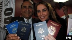 La periodista venezolana Lourdes Ubieta, acompañada de Carlos Herrades, muestran sus dos pasaportes, de Venezuela y Estados Unidos.