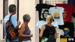 Un grupo de turistas observa varias camisetas entre las que destacan varias con la imagen del Che Guevara, en La Habana, Cuba.