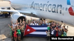 Empleados de American Airlines posan junto a uno de sus aviones con la bandera cubana. (Foto: American Airlines)