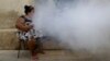 Una mujer fuma mientras soldados fumigan su vivienda para eliminar el agente transmisor del dengue y zika en La Habana. (Archivo-REUTERS/Ueslei Marcelino)