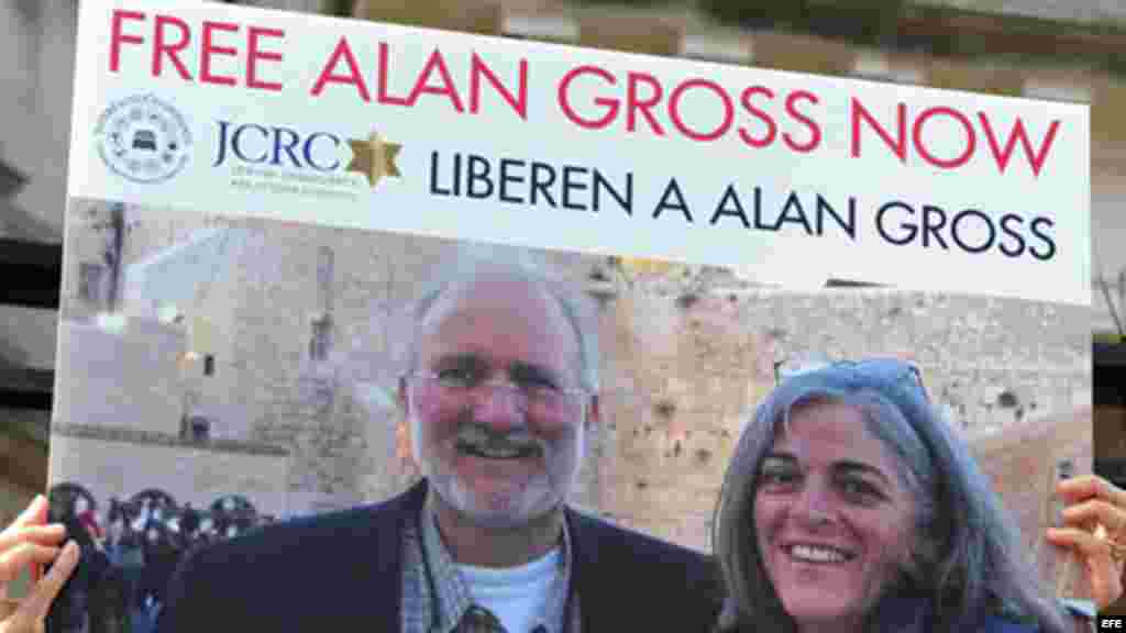 Una persona sostiene una pancarta en la que pide que sea liberado el contratista Alan Gross.