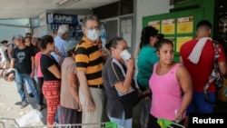 La gente espera en fila para comprar comida en un supermercado de La Habana.