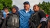 El gobernante Daniel Ortega, entre dos agentes policiales. (AP Foto/Cristóbal Venegas).