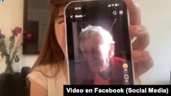 La activista cubana Carolina Barrero sostiene el teléfono con un video de Zoila Chávez, madre del escritor encarcelado José Gabriel Barrenechea.