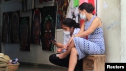 Vendedoras se protegen del contagio usando máscaras. REUTERS/Stringer