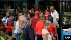 Lasgas filas para acceder al servicio de transporte público en La Habana.