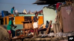 FOTO ARCHIVO. Una mujer se cepilla los dientes afuera de su casa dañada por el huracán Matthew, en Baracoa, el 7 de octubre de 2016. Los brotes de leptospirosis son muchas veces relacionados con inundaciones y huracanes.