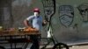 Un vendedor de vegetales en una calle de La Habana usa una máscara para protegerse del coronavirus, el 11 de abril de 2020. (Yamil Lage/AFP)