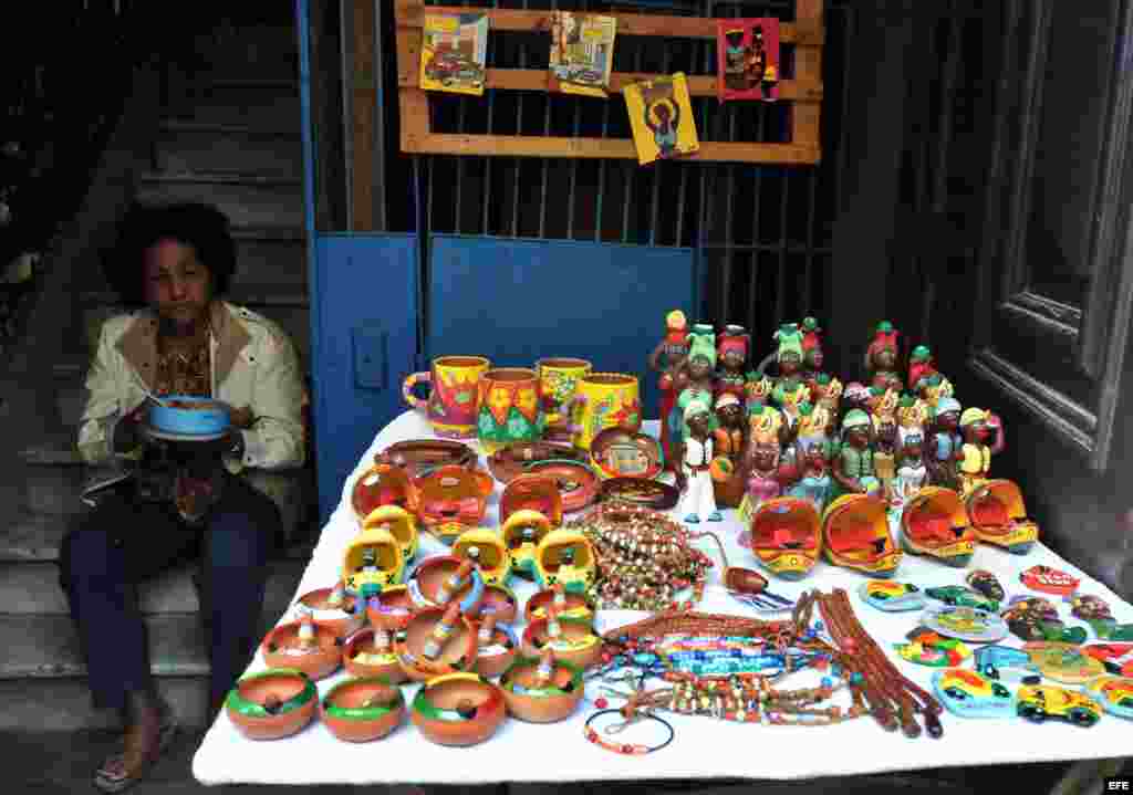 Archivo 2011- Una mujer vende artesanías y almuerza junto a su puesto en el sector de La Habana Vieja en La Habana (Cuba).