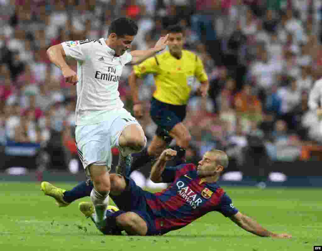 El defensa argentino del FC Barcelona Javier Mascherano (d) lucha un balón con el centrocampista colombiano del Real Madrid James Rodríguez (i).