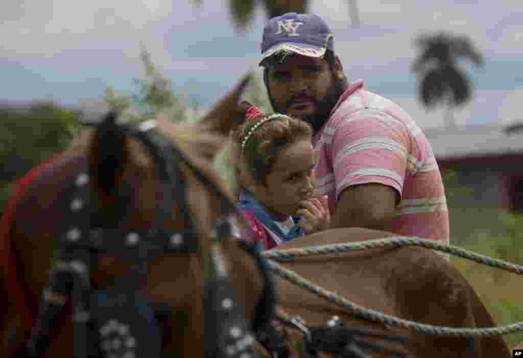 Una niña regresa de la escuela en el carro de caballos de su padre en Pinar del Río. La actual crisis energética de la nación isleña ha obligado a las autoridades a dar prioridad a los vehículos de tracción animal. (AP Foto / Ismael Francisco)
