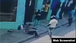 El video de la cámara de seguridad muestra a la víctima, vistiendo uniforme de la policía, tirada en el suelo, tras ser agredida por el hombre de la camiseta blanca.