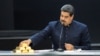 Nicolás Maduro toca una barra de oro mientras se dirige a los ministros responsables del sector económico en el Palacio de Miraflores.