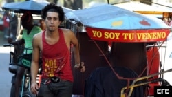 Un bicitaxista permanece al lado de su vehículo por las calles de La Habana (Cuba).