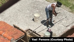 Residente saca agua de una cisterna en el reparto DBeche, Guanabacoa, La Habana.